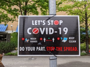 A sign that says "Let's Stop COVID-19. Do your part. Stop the Spread."