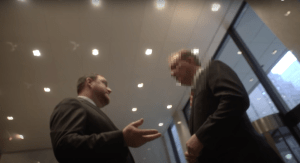 NCRP President and CEO Aaron Dorfman speaks with a Hess Corporation security official, whose face is blurred, during a visit to try to meet with Hess Foundation board chair John Hess.